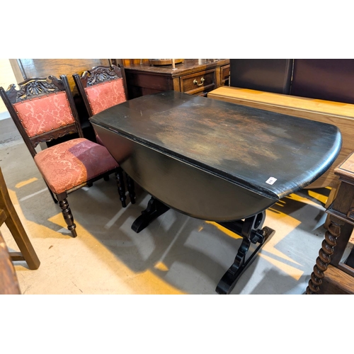 910 - An oak drop leaf dining table with refectory base and four dining chairs with carved slatt backs.