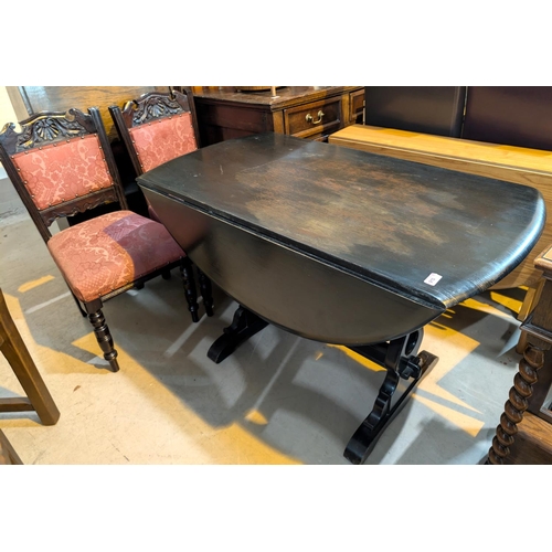 910 - An oak drop leaf dining table with refectory base and four dining chairs with carved slatt backs.