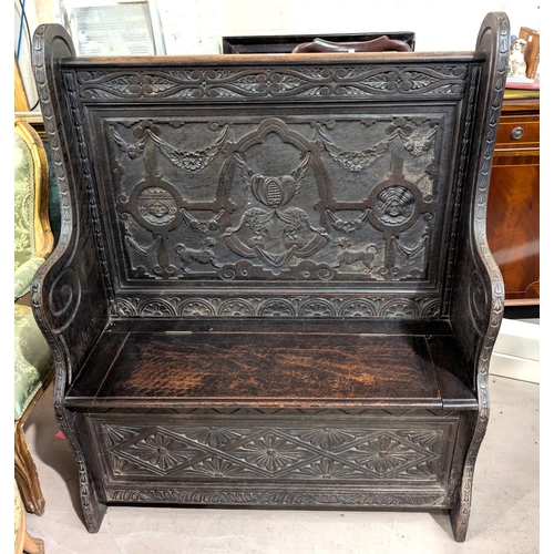 913 - A 19th century oak carved Jacobean style bench with box seat and carved Royal King and Queen to upri... 