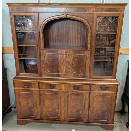 937 - A reproduction mahogany bookcase/display unit with fall-front drinks section doors and drawers below... 