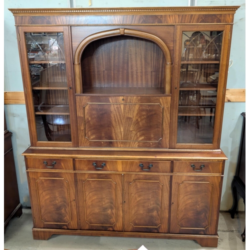 937 - A reproduction mahogany bookcase/display unit with fall-front drinks section doors and drawers below... 