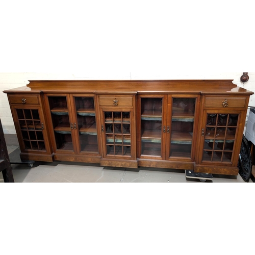 971 - Thos Turner, Manchester: a large low Arts and Crafts style walnut bookcase with 3 breakfront pedesta... 