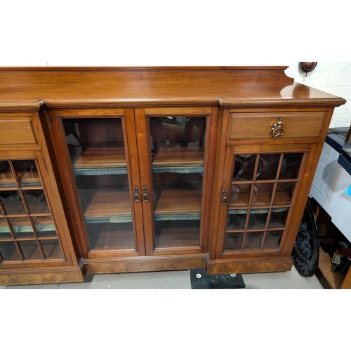 971 - Thos Turner, Manchester: a large low Arts and Crafts style walnut bookcase with 3 breakfront pedesta... 