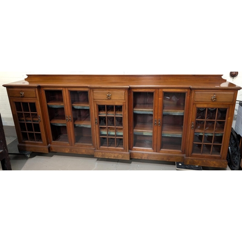 971 - Thos Turner, Manchester: a large low Arts and Crafts style walnut bookcase with 3 breakfront pedesta... 