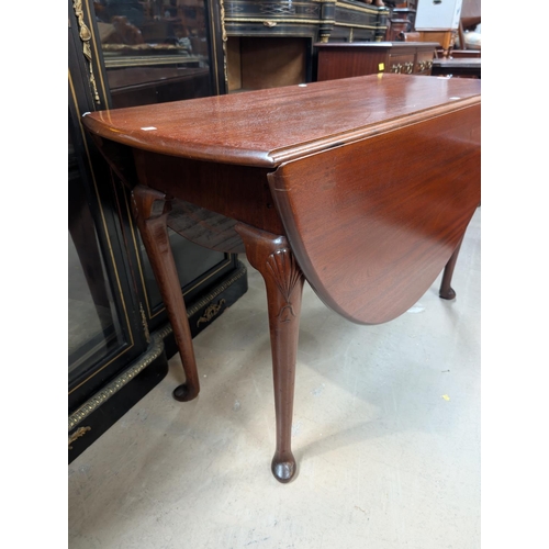 1015 - An Irish 19th century mahogany drop leaf dining table with shell carving to the top of each leg on p... 