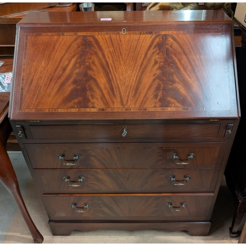 1042 - A reproduction mahogany bureau with fall front, drop handles frieze drawer and three others drawers