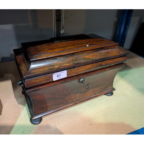 61 - A Georgian Rosewood sarcophagus tea caddy, waisted body, stepped lid, interior glass bowl.