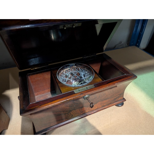 61 - A Georgian Rosewood sarcophagus tea caddy, waisted body, stepped lid, interior glass bowl.