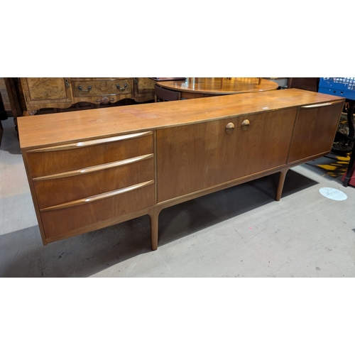 884 - A mid 20th century A H McIntosh Dunfermline teak sideboard with double doors, three drawers and a fu... 