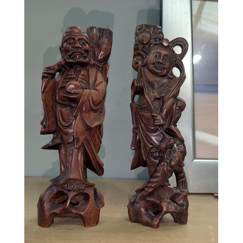 20 - A pair of Chinese root carvings, one sage fighting animal and another, height 31cm.