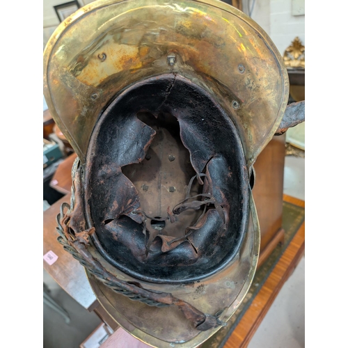 216 - A Victorian brass fireman's helmet with leather interior and strap.