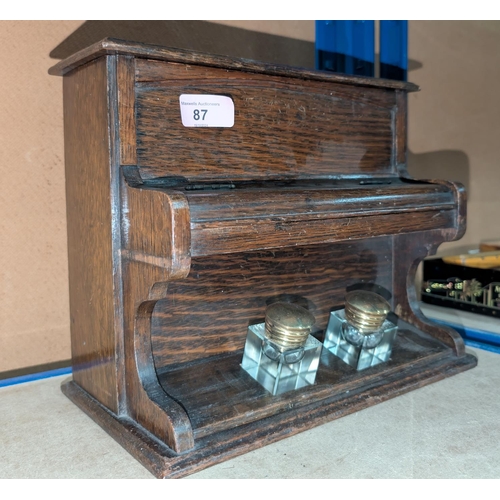 87 - A 1920's oak novelty inkstand in the form of a piano, with stationery compartment, 30cm wide.