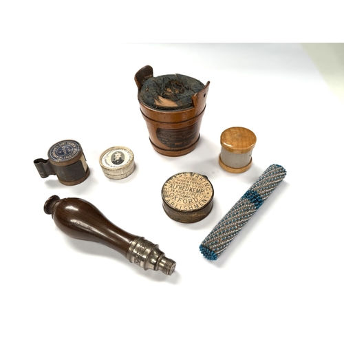 93 - A Thread waxer, 19th century Mauchline ware,  a similar pin cushion, other sewing requisites.