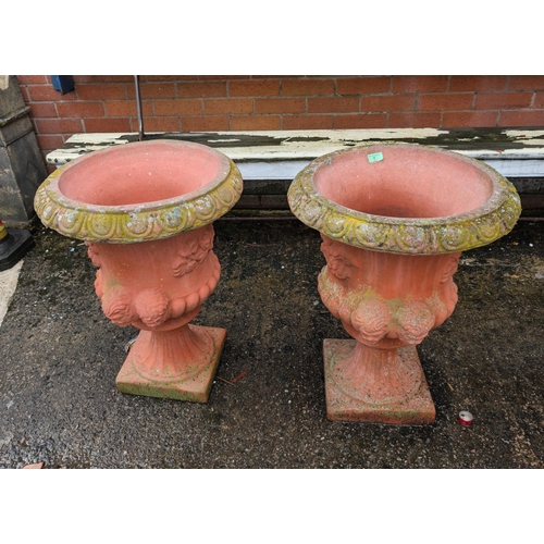 69 - A large pair of SANDFORD STONE composite campana shaped garden urns with floral and mask decoration,... 