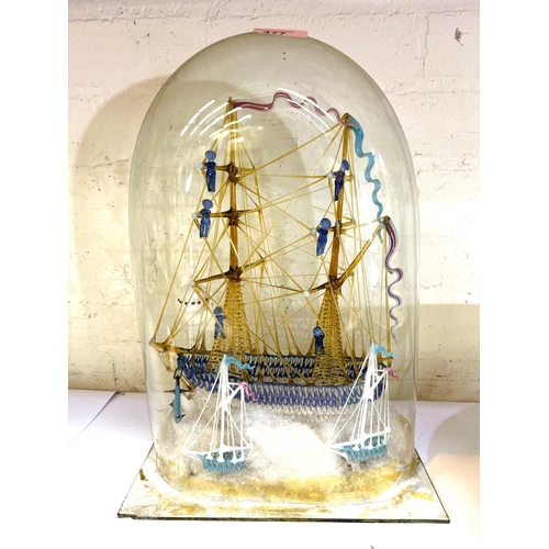 477 - A Victorian blown glass model of a two masted brig with sailors on rigging with small boats moored w... 