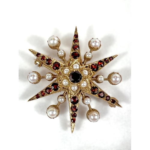 798A - A Victorian star brooch set with alternating rows of seed pearls and graduating garnets (unmarked).