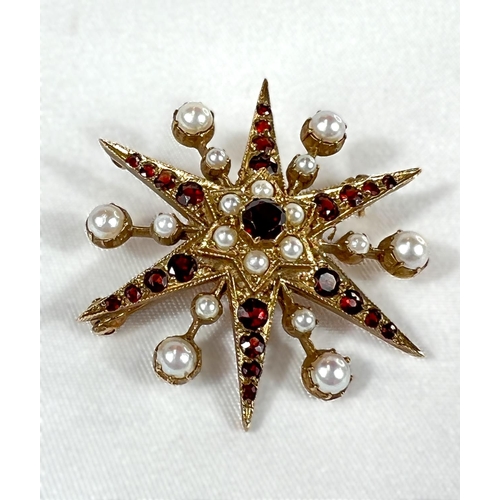 798A - A Victorian star brooch set with alternating rows of seed pearls and graduating garnets (unmarked).