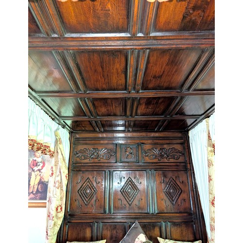 918 - An oak four poster bed with solid canopy above, carved detail to foot and head, with turned supports... 