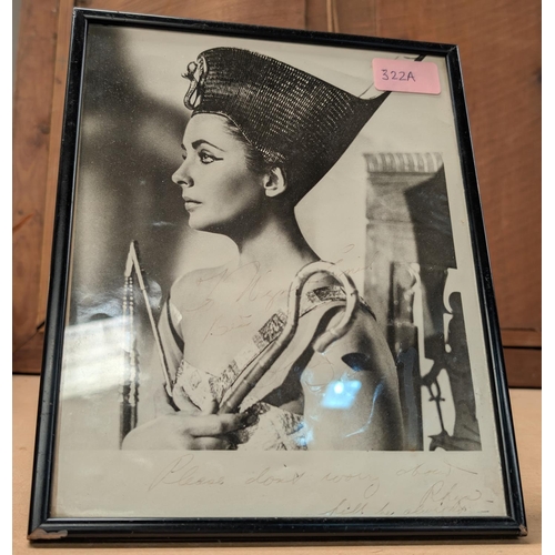 322A - A signed publicity photo of Elizabeth Taylor, framed, (family history), faded.