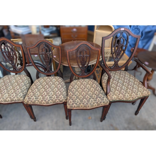 980 - A set of six (four and two) inlaid shield back dining chairs with central motif.