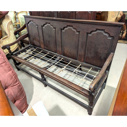 869 - A 19th Century bench/settle with high panel back and arm rests.