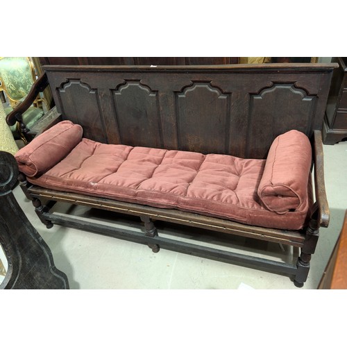 869 - A 19th Century bench/settle with high panel back and arm rests.