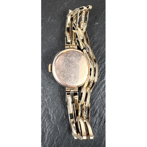 656 - A lady's vintage wristwatch with 9ct gold case and strap - gross weight 23gm.