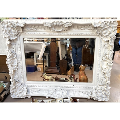 852 - A large rectangular white framed bevelled edge wall mirror in shell and acanthus show frame.