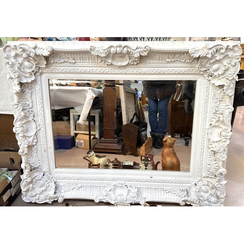 852 - A large rectangular white framed bevelled edge wall mirror in shell and acanthus show frame.