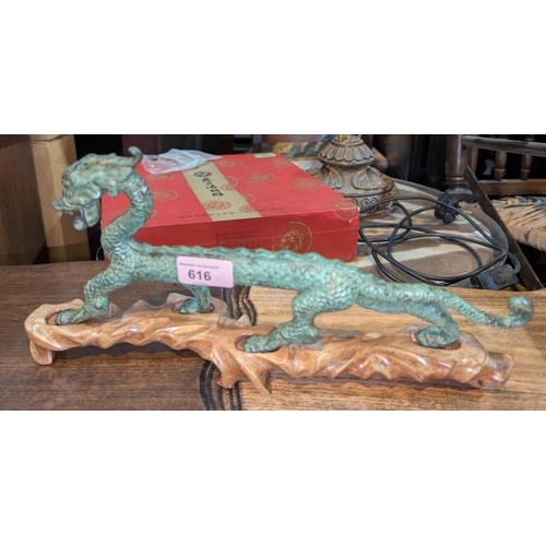 616 - A Chinese patinated bronze figure of a dragon, 32cm, hardwood base