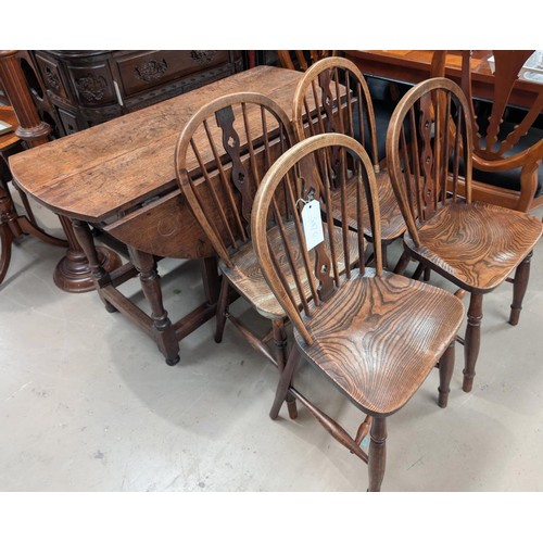 842C - An 18th century circular oak drop leaf table and a set of 4 elm Windsor wheel back dining chairs