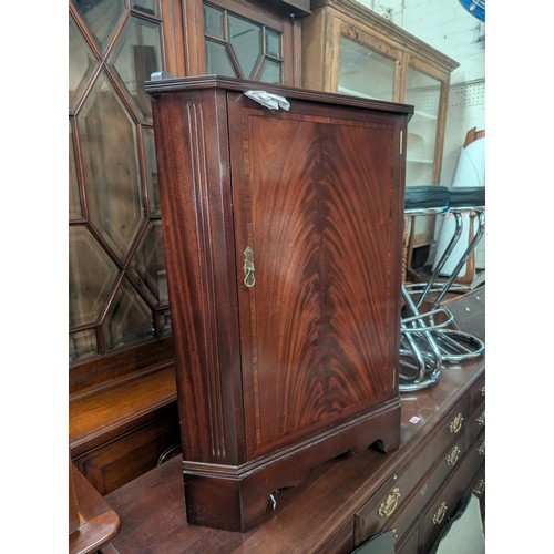 1044 - A mahogany floor standing corner cupboard with single door and a similar glass top table