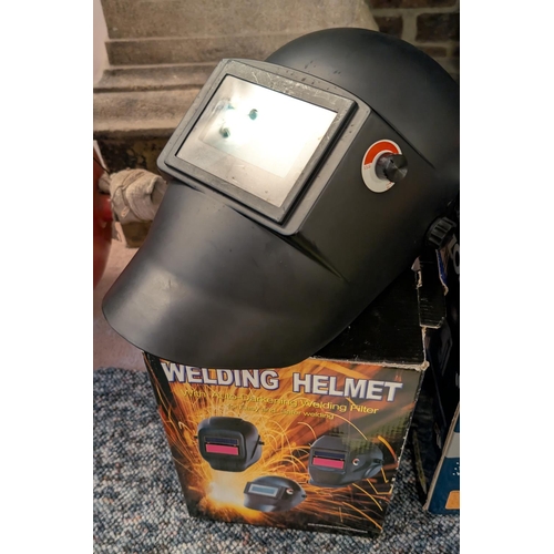 25 - A welding helmet with auto darkening filter, boxed.