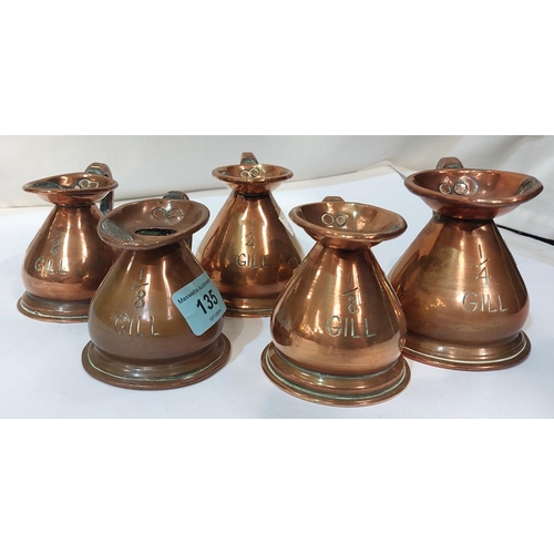 135 - 5 copper jugs, 1/8th gill to 1/2 gill, each with pewter stamps to the rim.