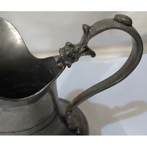 303 - A 19th Century pewter jug with stamps to base and dragon on handle, height 20cm.