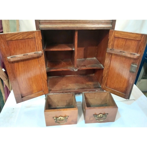 315 - An oak double door smokers cabinet and a selection of plate and metalware.