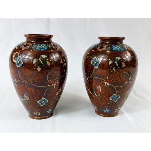 413 - A pair of Japanese Meiji period rust ground Cloisonne vases with scrolling branch and butterfly deco... 