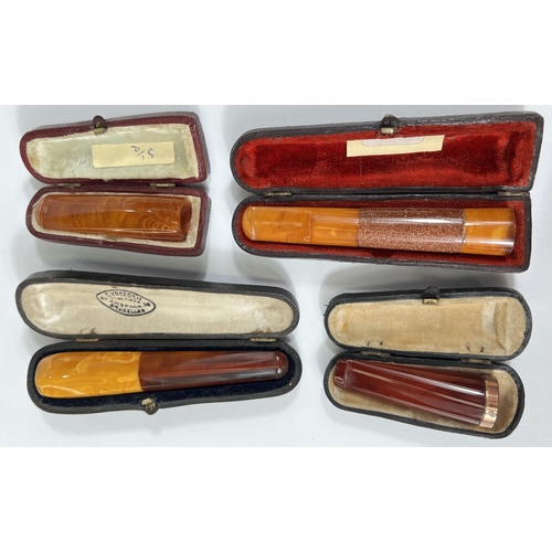 42 - 4 cased amber cigar holders, one with 9 carat mount.