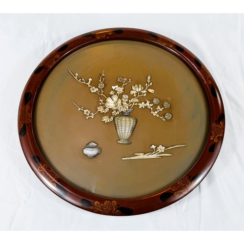 422 - A circular Japanese/Chinese relief picture depicting a vase of flowers in mother of pearl etc, in re... 