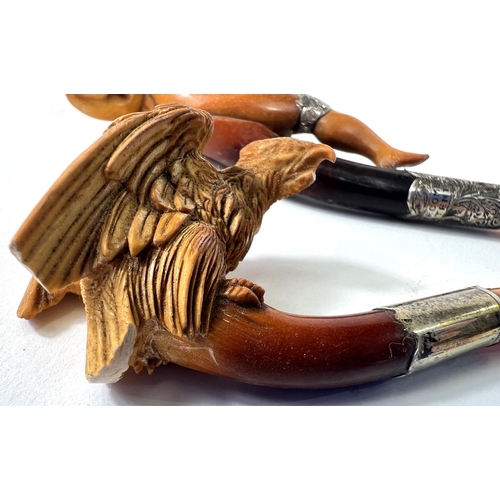 43 - An unusual cased pair of amber and Meerschaum pipes, one depicting a naked woman, the other an eagle... 