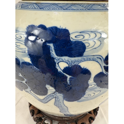 433A - A Chinese blue and white ginger jar on associated stand with wooden decorated with trees and animals... 