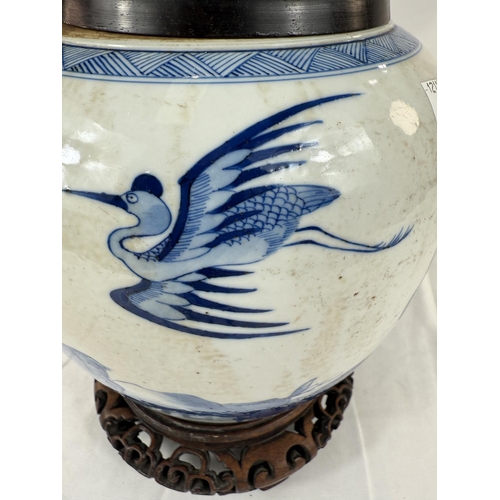 433A - A Chinese blue and white ginger jar on associated stand with wooden decorated with trees and animals... 