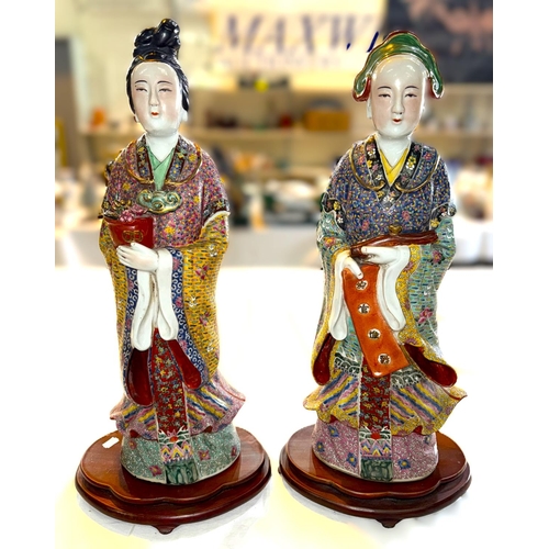 434A - A large pair of Chinese ceramic figures on stands, polychrome decoration to their traditional robes,... 