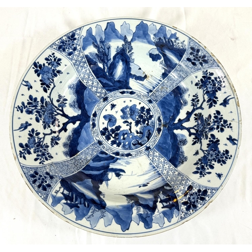 453 - A Chinese Kangxi period blue charger with blue and white decoration of trees and flowers, flower mar... 