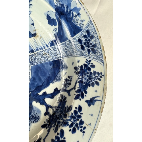 453 - A Chinese Kangxi period blue charger with blue and white decoration of trees and flowers, flower mar... 