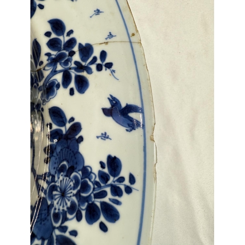 453 - A Chinese Kangxi period blue charger with blue and white decoration of trees and flowers, flower mar... 