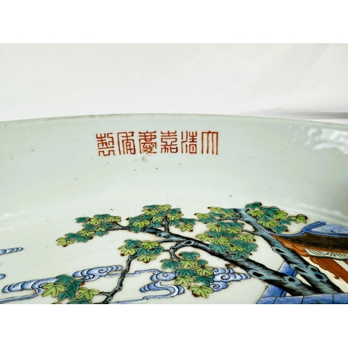 458 - A large and impressive Chinese shallow bowl with polychrome decoration of traditional courtyard scen... 