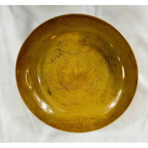 459 - A Chinese yellow shallow dish with incised dragon decoration to centre and outside rim, four charact... 