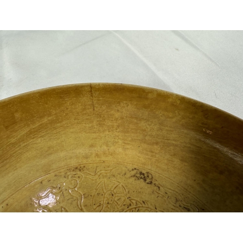 459 - A Chinese yellow shallow dish with incised dragon decoration to centre and outside rim, four charact... 