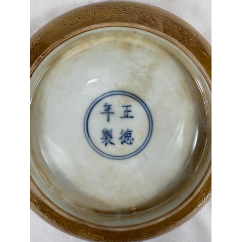 459 - A Chinese yellow shallow dish with incised dragon decoration to centre and outside rim, four charact... 